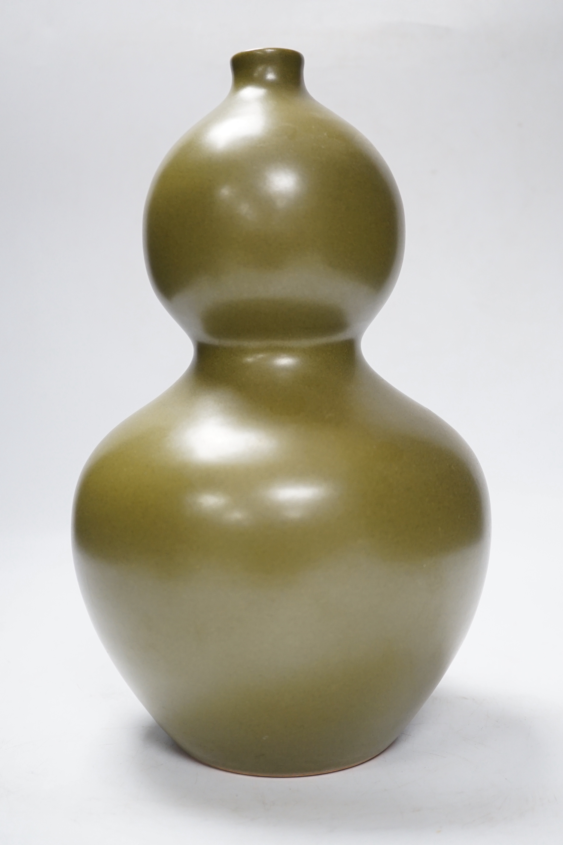 A Chinese olive-green double gourd vase, 29cm high
